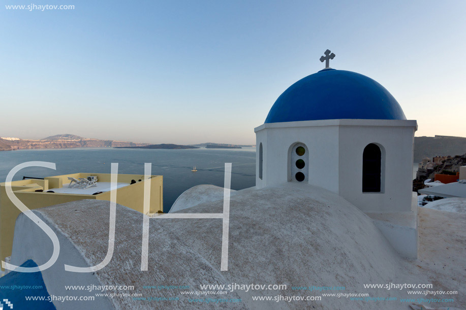 Church with blue roof in town of Oia and panorama to Santorini island, Thira, Cyclades, Greece