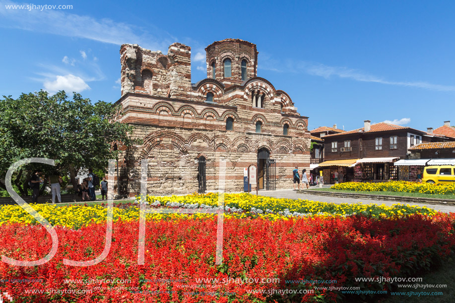 NESSEBAR, BULGARIA - AUGUST 12, 2018: Flower garden in front of Ancient Church of Christ Pantocrator in the town of Nessebar, Burgas Region, Bulgaria