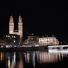 Night photo of  Grossmunster  church and bridge over Limmat River, city of Zurich, Switzerland