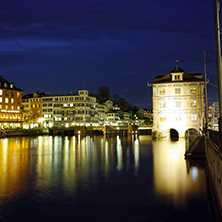 Night photo of city of Zurich and reflection in Limmat River, Switzerland