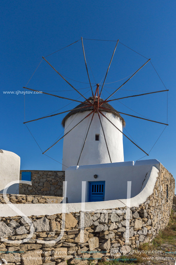 White windmill and Stone wall on the island of Mykonos, Cyclades, Greece