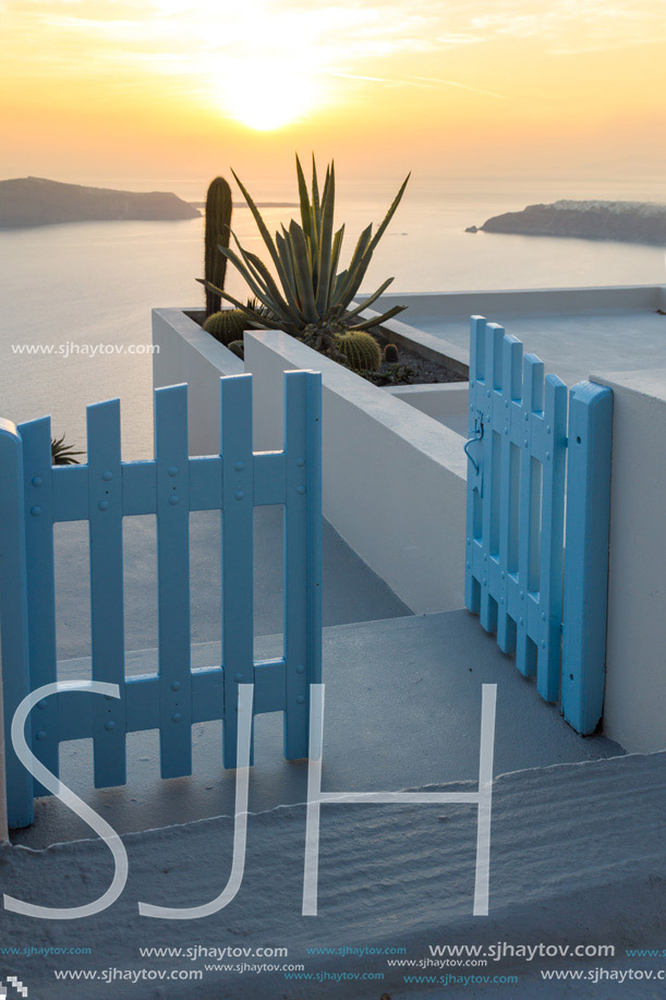 Entrance of white house and sunset in town of Imerovigli, Santorini island, Thira, Cyclades, Greece