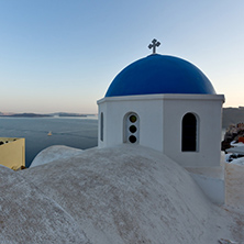 Church with blue roof in town of Oia and panorama to Santorini island, Thira, Cyclades, Greece