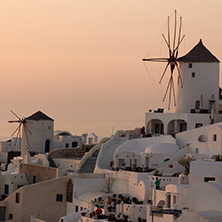 Amazing Sunset over white windmills in  town of Oia and panorama to Santorini island, Thira, Cyclades, Greece