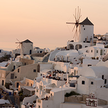 Amazing Sunset over white windmills in  town of Oia and panorama to Santorini island, Thira, Cyclades, Greece