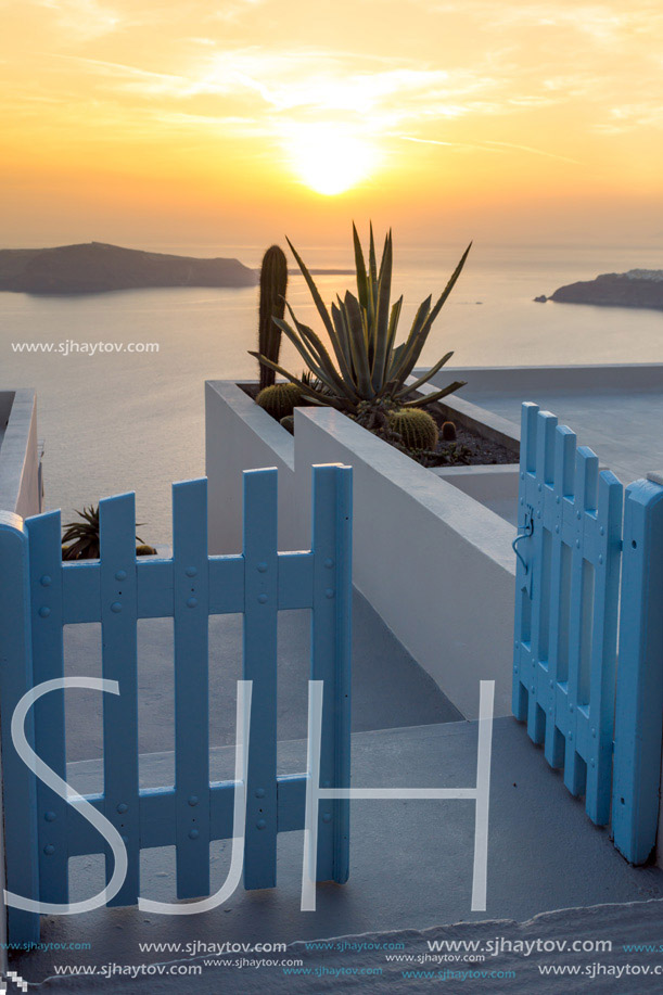 Entrance of white house and sunset in town of Imerovigli, Santorini island, Thira, Cyclades, Greece