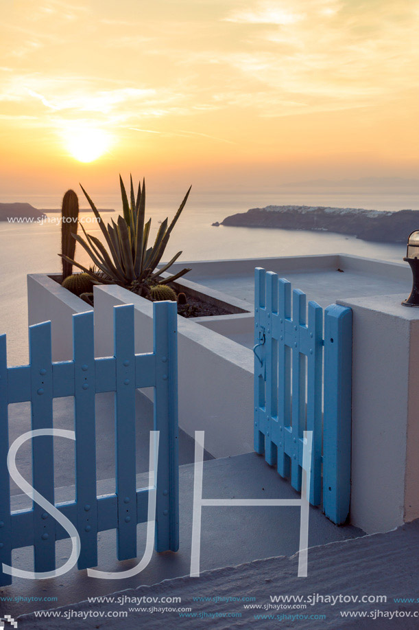 Entrance of white house and sunset in town of Imerovigli, Santorini island, Thira, Cyclades, Greece