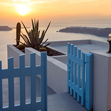 Entrance of white house and sunset in town of Imerovigli, Santorini island, Thira, Cyclades, Greece