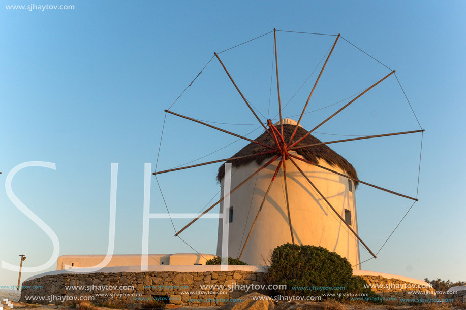 The last rays of the sun over White windmills on the island of Mykonos, Cyclades, Greece