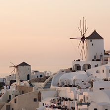Amazing Sunset over white windmills in  town of Oia and panorama to Santorini island, Thira, Cyclades, Greece