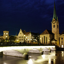 Night photo of Fraumunster Church and bridge over Limmat River, city of Zurich, Switzerland