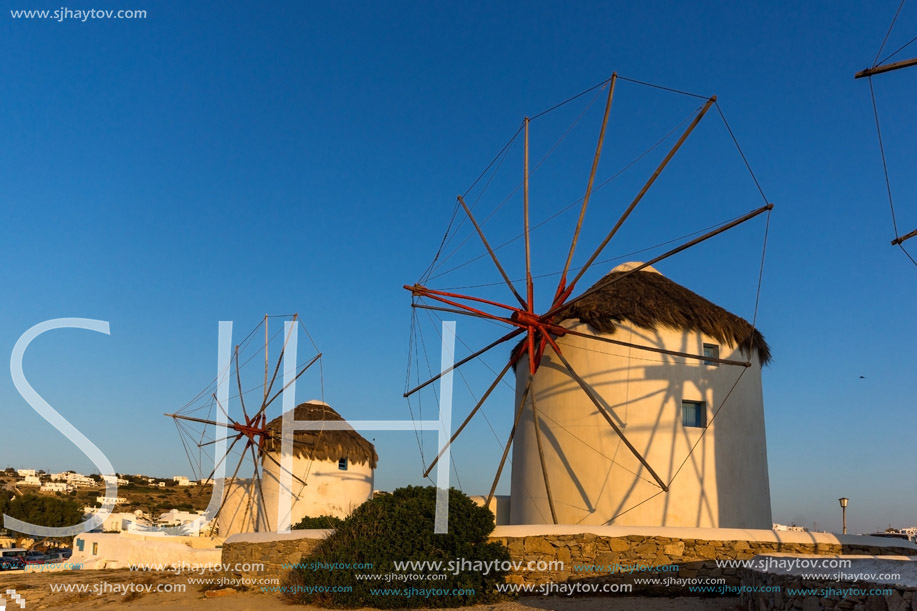 The last rays of the sun over White windmills on the island of Mykonos, Cyclades, Greece