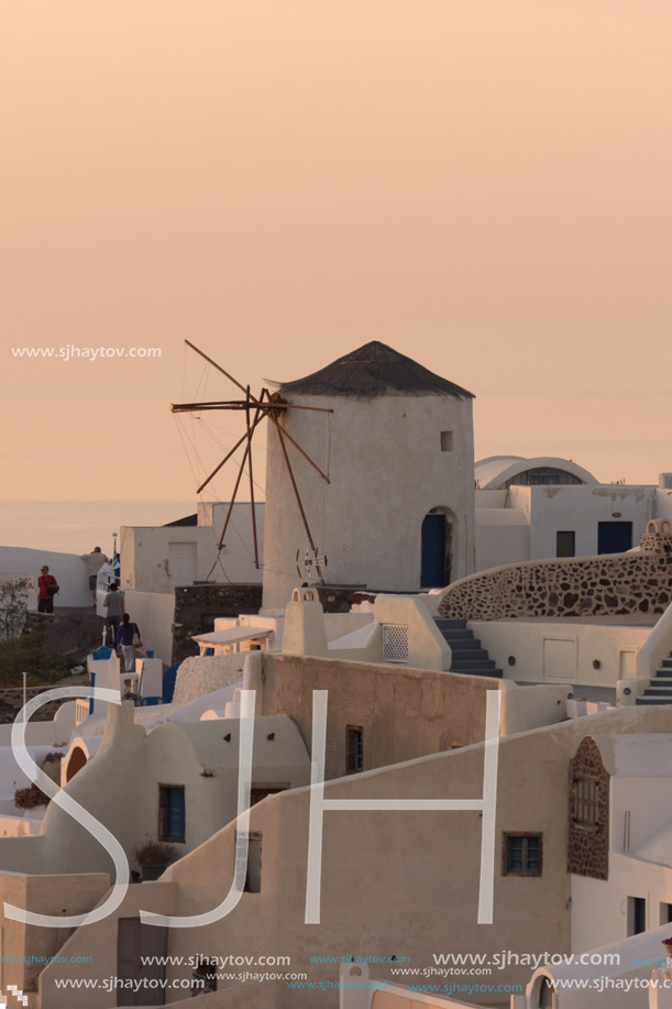 Amazing Sunset over white windmills in  town of Oia and panorama to Santorini island, Thira, Cyclades, Greece