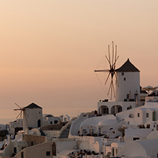 Amazing Sunset over white windmills in  town of Oia and panorama to Santorini island, Thira, Cyclades, Greece