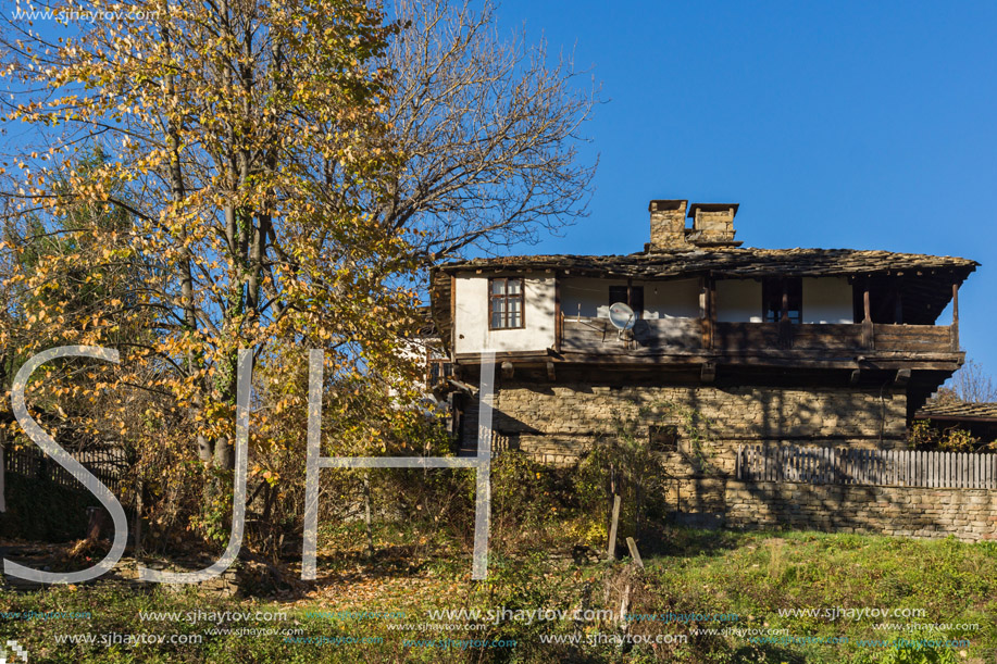 Panorama with Old house and autumn tree with courtyard in village of Bozhentsi, Gabrovo region, Bulgaria