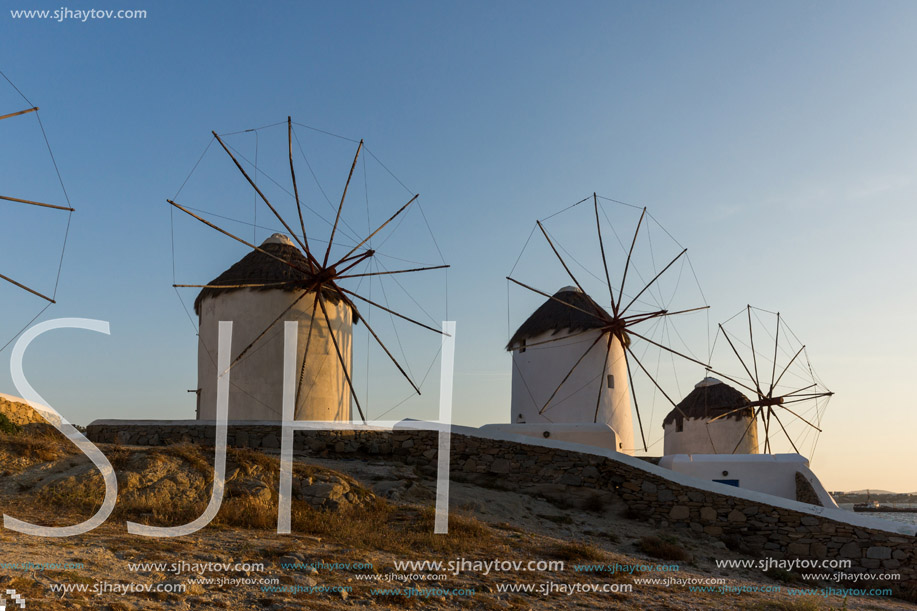 Sunset of White windmills and Aegean sea on the island of Mykonos, Cyclades, Greece