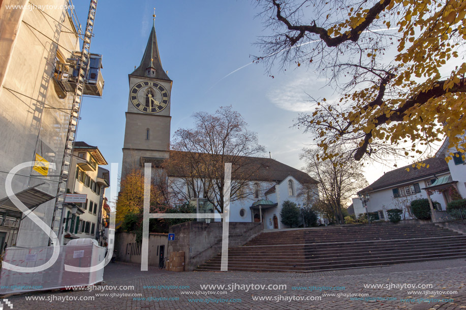 ZURICH, SWITZERLAND - OCTOBER 28, 2015:  St. Peter Church and autumn trees, City of Zurich, Switzerland