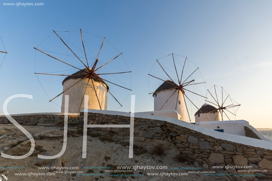 Sunset of White windmills and Aegean sea on the island of Mykonos, Cyclades, Greece