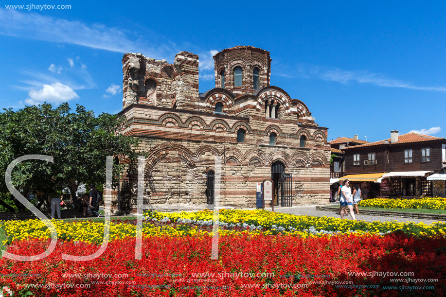 NESSEBAR, BULGARIA - AUGUST 12, 2018: Flower garden in front of Ancient Church of Christ Pantocrator in the town of Nessebar, Burgas Region, Bulgaria