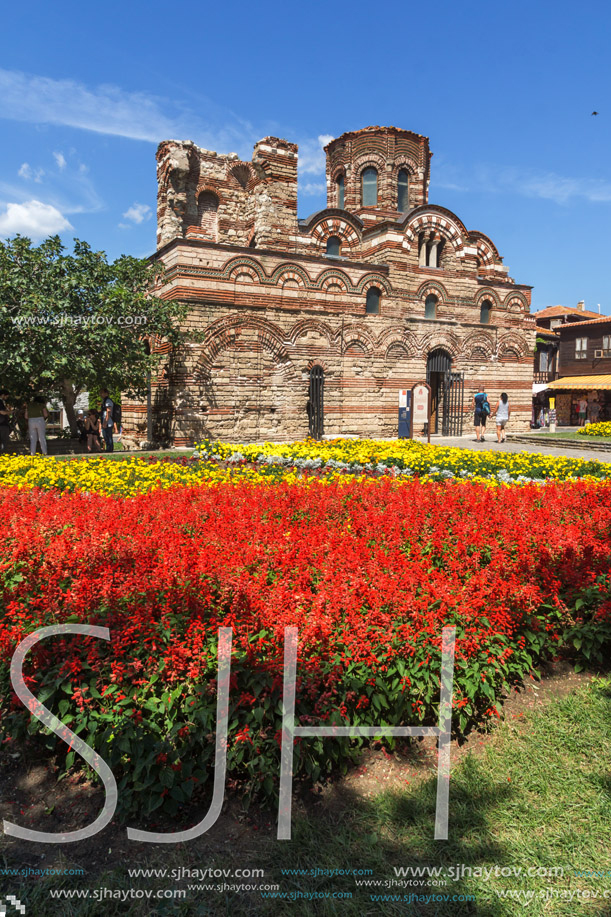 NESSEBAR, BULGARIA - AUGUST 12, 2018: Flower garden in front of Ancient Church of Christ Pantocrator in the town of Nessebar, Burgas Region, Bulgaria