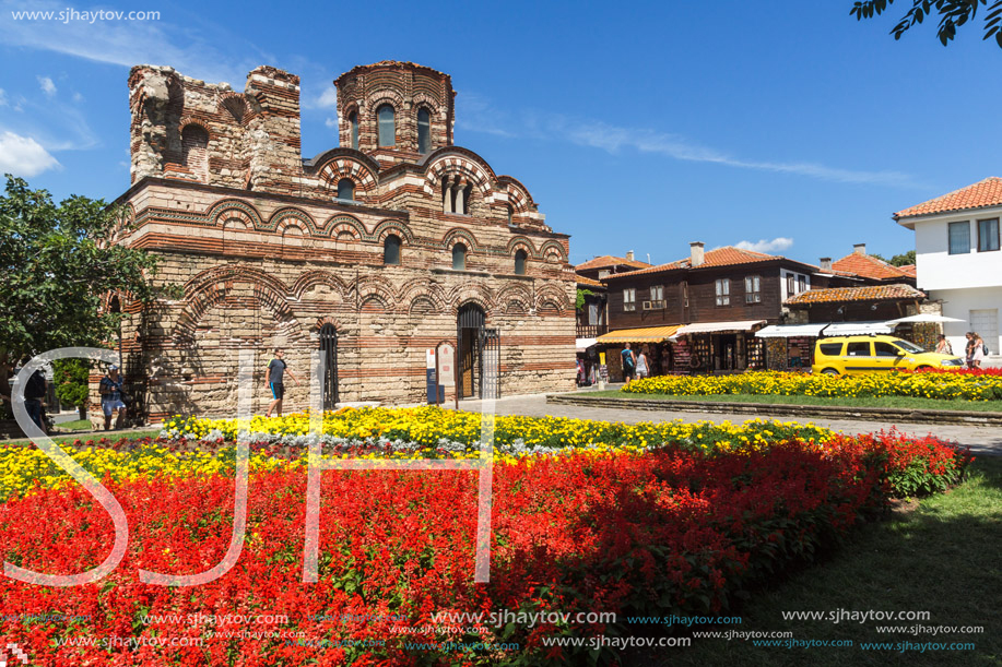 NESSEBAR, BULGARIA - AUGUST 12, 2018: Flower garden in front of Ancient Church of Christ Pantocrator in the town of Nessebar, Burgas Region, Bulgaria