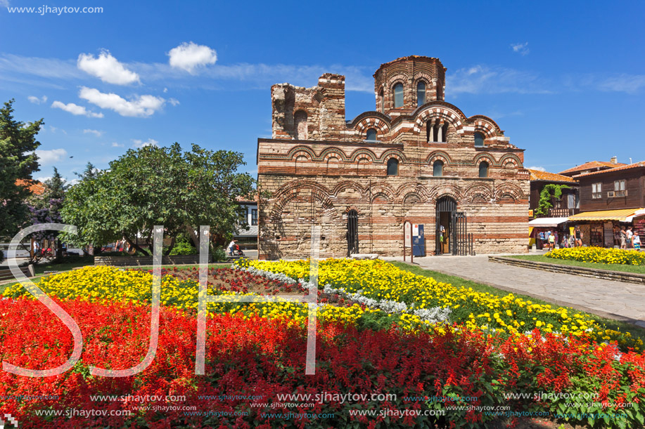 NESSEBAR, BULGARIA - AUGUST 12, 2018: Flower garden in front of Ancient Church of Christ Pantocrator in the town of Nessebar, Burgas Region, Bulgaria