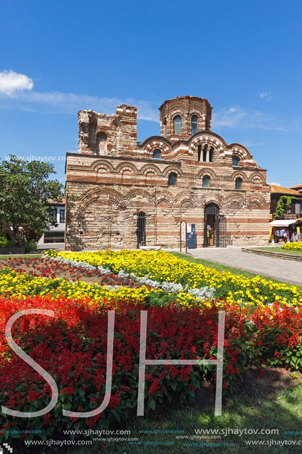 NESSEBAR, BULGARIA - AUGUST 12, 2018: Flower garden in front of Ancient Church of Christ Pantocrator in the town of Nessebar, Burgas Region, Bulgaria