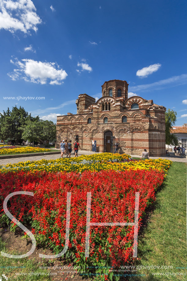 NESSEBAR, BULGARIA - AUGUST 12, 2018: Flower garden in front of Ancient Church of Christ Pantocrator in the town of Nessebar, Burgas Region, Bulgaria