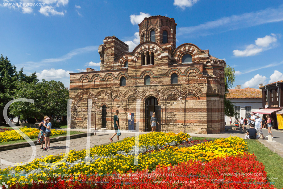 NESSEBAR, BULGARIA - AUGUST 12, 2018: Flower garden in front of Ancient Church of Christ Pantocrator in the town of Nessebar, Burgas Region, Bulgaria