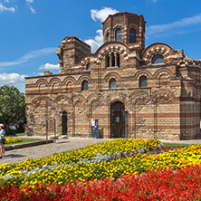 NESSEBAR, BULGARIA - AUGUST 12, 2018: Flower garden in front of Ancient Church of Christ Pantocrator in the town of Nessebar, Burgas Region, Bulgaria