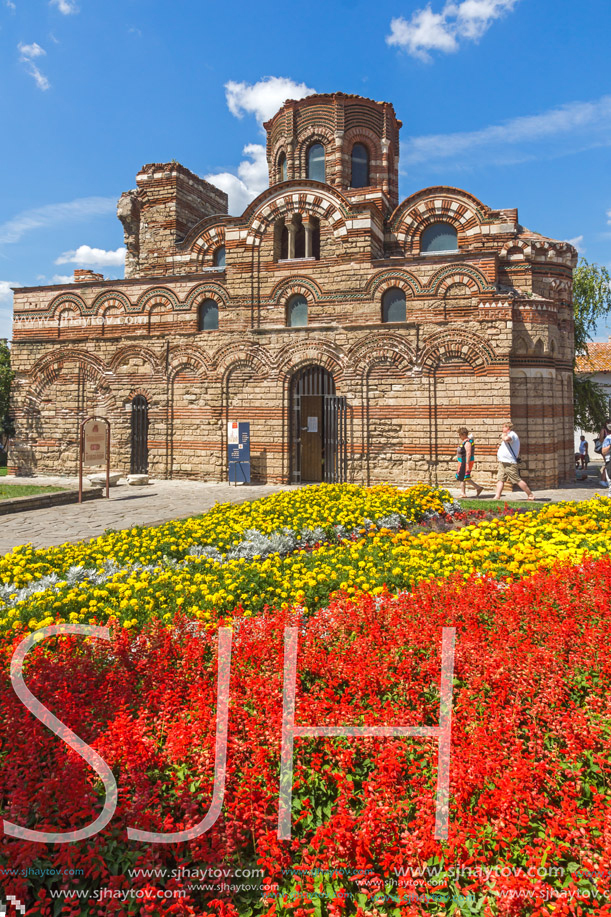 NESSEBAR, BULGARIA - AUGUST 12, 2018: Flower garden in front of Ancient Church of Christ Pantocrator in the town of Nessebar, Burgas Region, Bulgaria