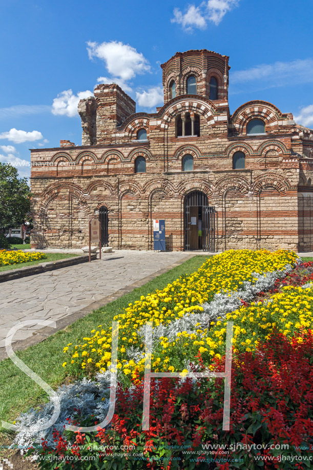 NESSEBAR, BULGARIA - AUGUST 12, 2018: Flower garden in front of Ancient Church of Christ Pantocrator in the town of Nessebar, Burgas Region, Bulgaria