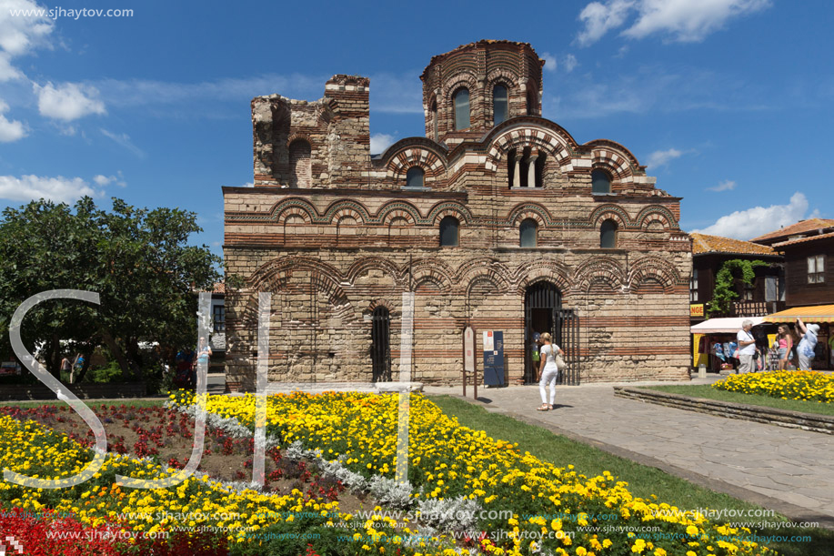 NESSEBAR, BULGARIA - AUGUST 12, 2018: Flower garden in front of Ancient Church of Christ Pantocrator in the town of Nessebar, Burgas Region, Bulgaria