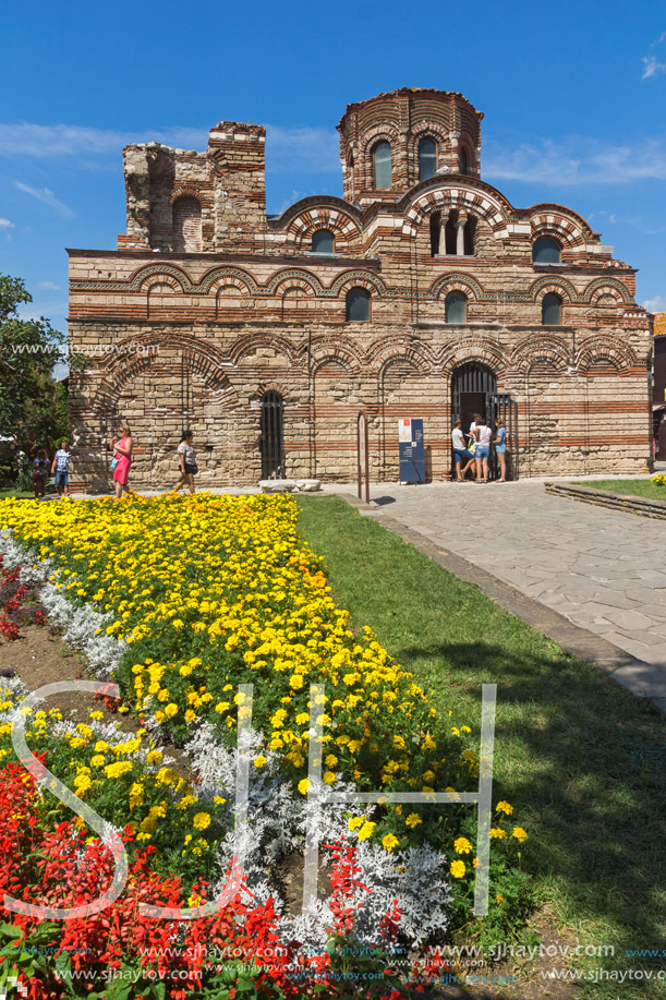 NESSEBAR, BULGARIA - AUGUST 12, 2018: Flower garden in front of Ancient Church of Christ Pantocrator in the town of Nessebar, Burgas Region, Bulgaria