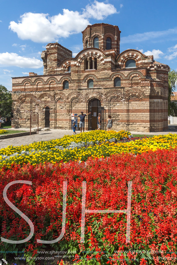 NESSEBAR, BULGARIA - AUGUST 12, 2018: Flower garden in front of Ancient Church of Christ Pantocrator in the town of Nessebar, Burgas Region, Bulgaria