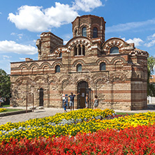 NESSEBAR, BULGARIA - AUGUST 12, 2018: Flower garden in front of Ancient Church of Christ Pantocrator in the town of Nessebar, Burgas Region, Bulgaria