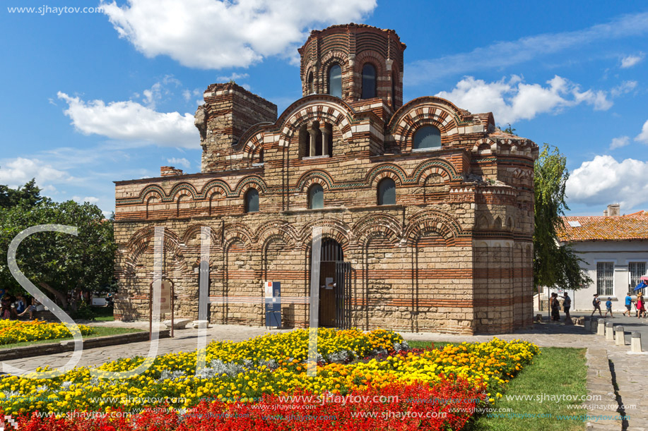 NESSEBAR, BULGARIA - AUGUST 12, 2018: Flower garden in front of Ancient Church of Christ Pantocrator in the town of Nessebar, Burgas Region, Bulgaria
