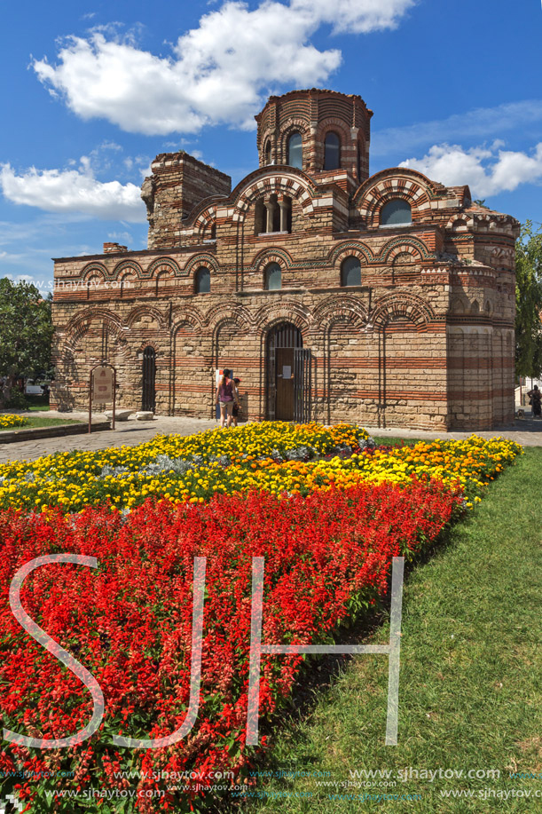 NESSEBAR, BULGARIA - AUGUST 12, 2018: Flower garden in front of Ancient Church of Christ Pantocrator in the town of Nessebar, Burgas Region, Bulgaria